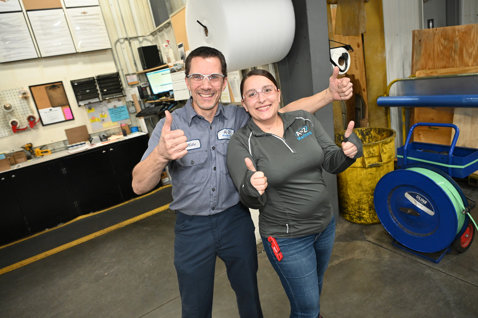 Two A to Z Machine employees giving thumbs up together