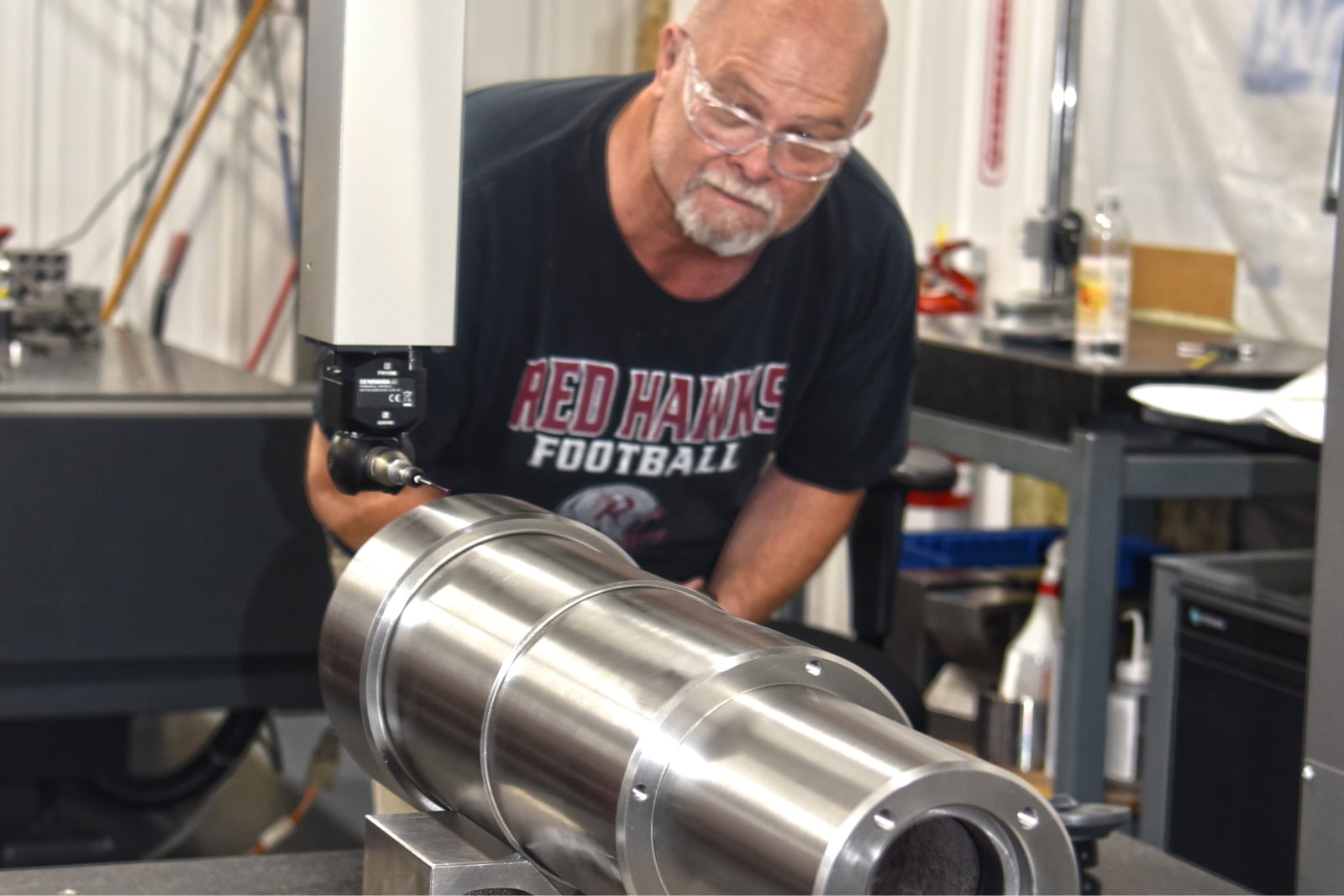 A to Z Machine employee looking at custom-machined component during quality inspection