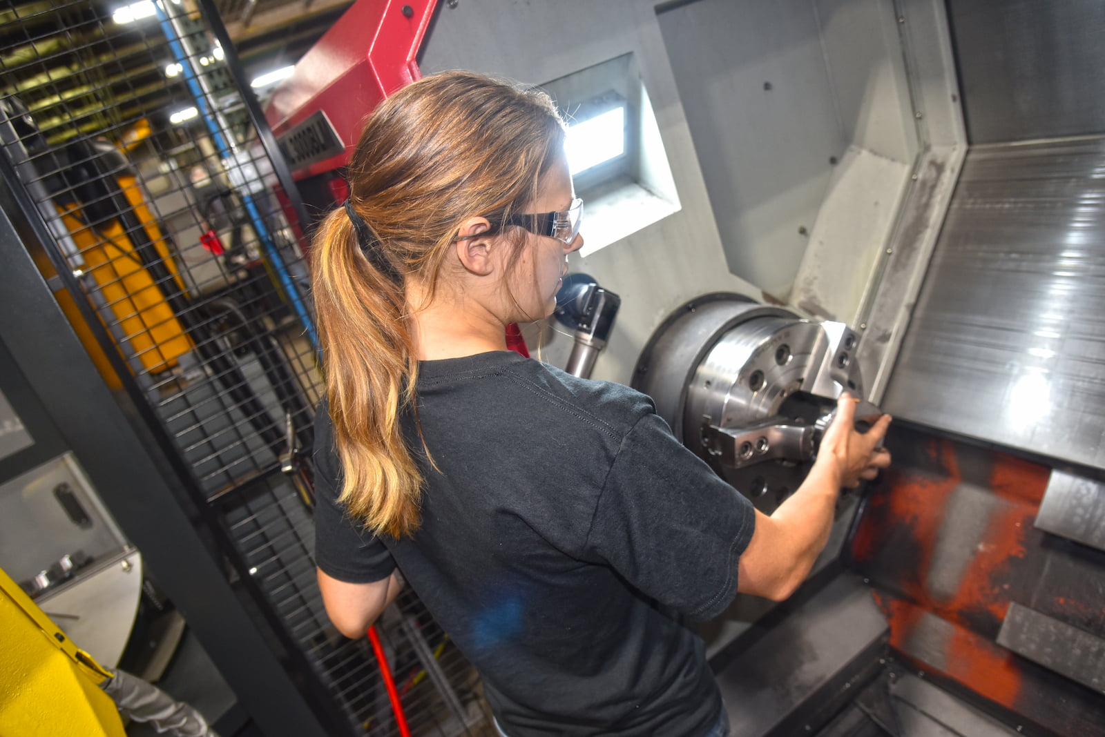 Young woman working on CNC machine